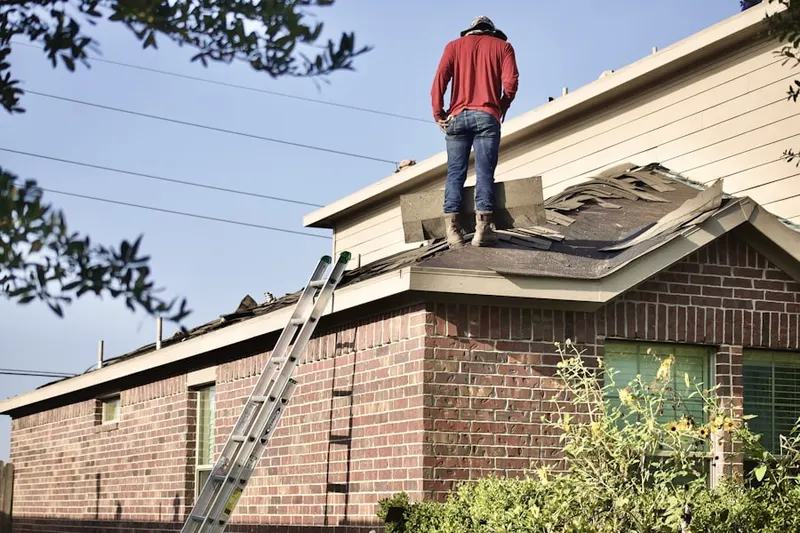 Professional roofer working on a residential roof in Arden